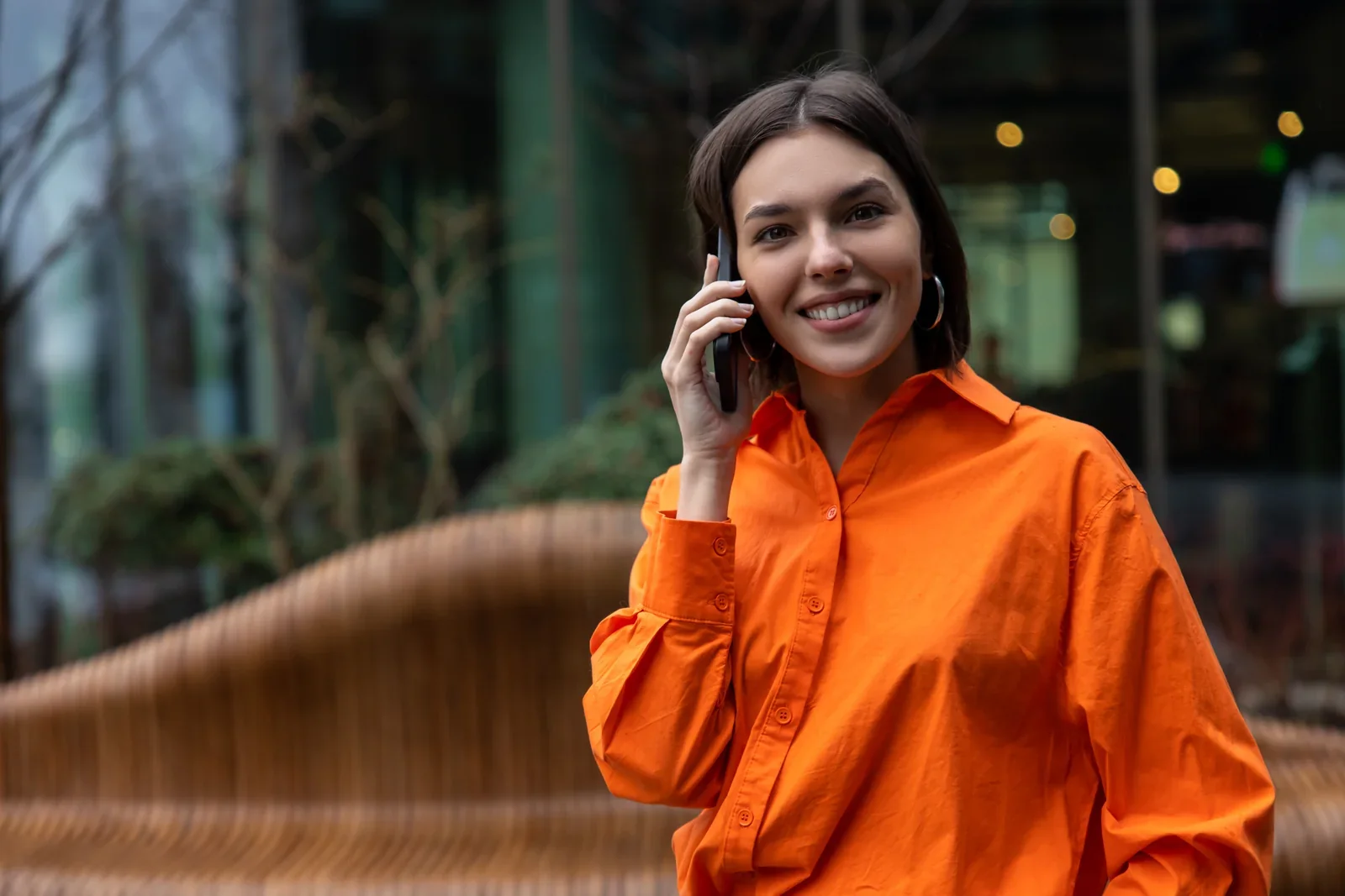 Mulher sorrindo ao telefone na rua